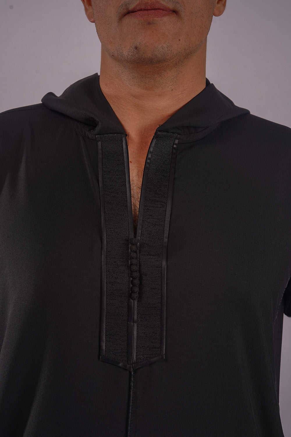 Model showcases Aamsah's Hooded Black Thobe, blending traditional Islamic attire with modern elements, a competitor to My Little Jubba and MuslimAmerican.com.