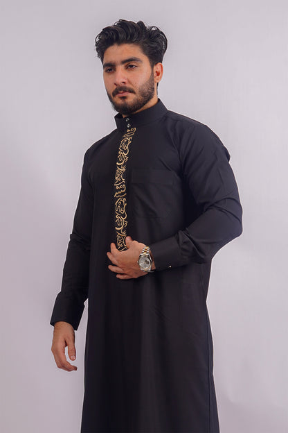 Aamsah's Black Saudi Thobe: Intricate golden embroidery on a sophisticated black backdrop, tailored for elegance and Muslim ceremonies.