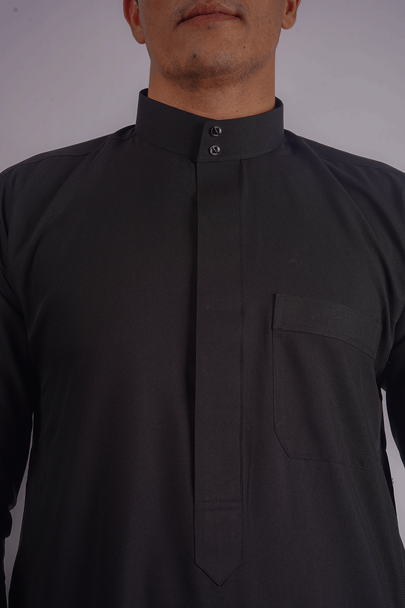 Experience elegance with Aamsah's Black Saudi & Kuwaiti Thobe. Crafted from premium spun fabric, this men's thobe features a Saudi collar, long sleeves, and a front pocket, blending traditional style with modern sophistication for any setting.