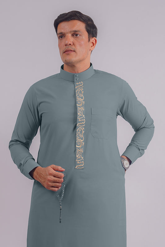 Elegant Dusty Blue Saudi Thobe by Aamsah, featuring intricate golden embroidery inspired by traditional Saudi craftsmanship, ideal for special occasions.