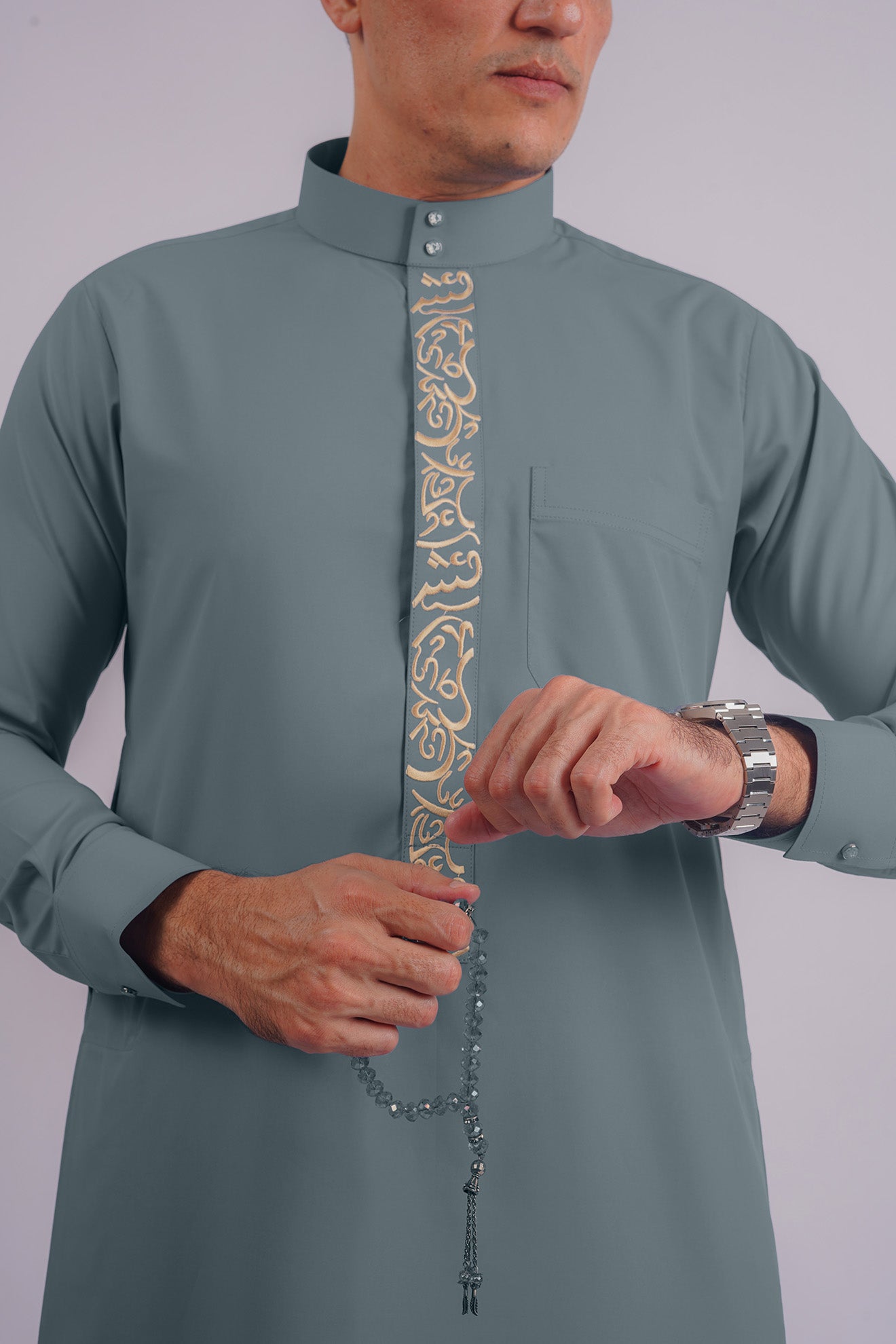 Sophisticated Dusty Blue Thobe with Golden Detailing by Aamsah, a fusion of Saudi heritage and contemporary fashion, suited for formal and cultural events.